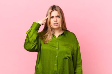 Kıvrımlı, güzel sarışın kadın kafası karışık ve şaşkın hissediyor, deli olduğunu gösteriyor.