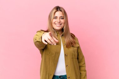 Seni seçen kıvrımlı, sarışın kadın kamerayı işaret ediyor.