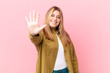 Kıvrımlı, güzel sarışın kadın gülümsüyor ve arkadaş canlısı görünüyor.