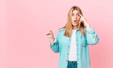 Kıvrımlı, güzel, sarışın kadın şaşırmış görünüyor, yeni bir düşünce, fikir ya da konsept keşfediyor.