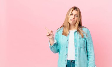 Kıvrımlı, güzel, sarışın kadın üzgün ve sızlanıyor, mutsuz bir bakışla ve ağlamayla.