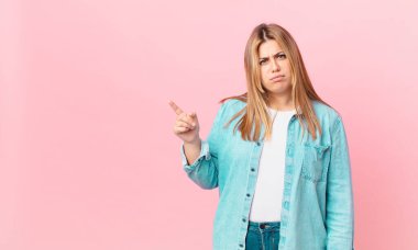 kıvrımlı, güzel sarışın kadın şaşkın ve şaşkın hissediyor.