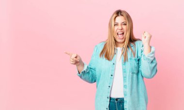 kıvrımlı, güzel sarışın kadın sinirli bir ifadeyle bağırıyor.