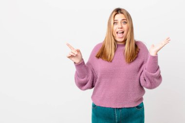 Kıvrımlı, güzel sarışın kadın inanılmaz bir şey karşısında mutlu ve şaşkın hissediyor.