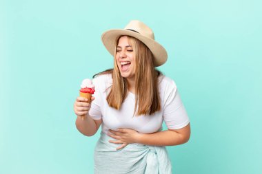 Kıvrımlı, güzel, sarışın kadın komik bir şakaya yüksek sesle gülüyor.