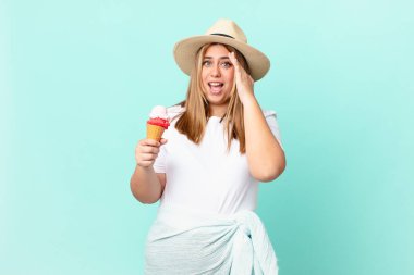 Kıvrımlı, güzel, sarışın kadın mutlu, şaşkın ve şaşkın görünüyor.