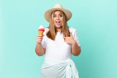 Kıvrımlı, güzel, sarışın kadın mutlu hissediyor ve heyecanlı bir şekilde kendini işaret ediyor.