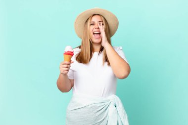 Kıvrımlı, güzel sarışın kadın mutlu hissediyor, elleri ağzının kenarında bağırıyor.