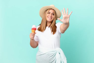 Kıvrımlı, güzel sarışın kadın gülümsüyor ve arkadaş canlısı görünüyor.