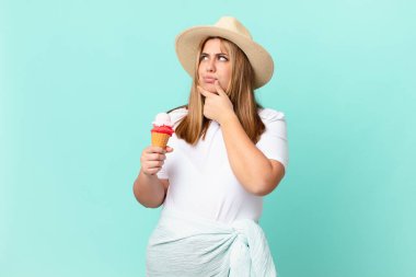 kıvrımlı, güzel sarışın kadın düşünüyor, kuşkulu ve şaşkın hissediyor.