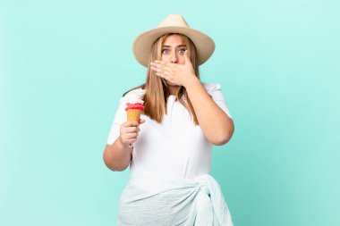 Kıvrımlı, güzel, sarışın kadın, elleri ile ağzını kapatıyor.