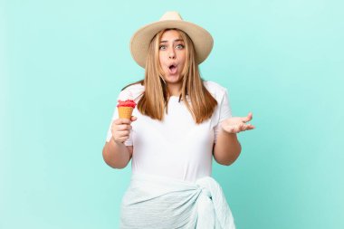 Kıvrımlı, güzel, sarışın kadın şok olmuş ve şaşırmış hissediyor.