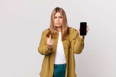 kıvrımlı, güzel, sarışın bir kadın kızgın, sinirli, asi ve agresif ve akıllı bir telefon tutuyor.