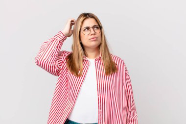 Kıvrımlı, güzel, sarışın kadın kafası karışmış, kaşınıyor.