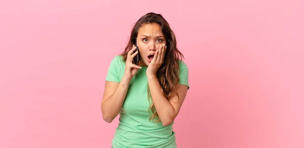 Joven Bonita Mujer Sintiéndose Sorprendido Asustado Sosteniendo Teléfono Inteligente —  Fotos de Stock
