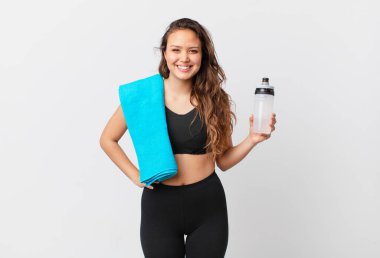 Genç ve güzel bir kadın mutlu bir şekilde gülümsüyor, eli kalçasında ve kendinden emin. fitness konsepti