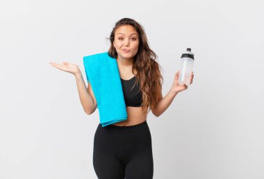 Genç ve güzel bir kadın şaşkın, şaşkın ve şüpheci hissediyor. fitness konsepti