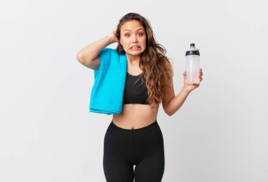 Genç ve güzel bir kadın gergin, endişeli ya da korkmuş hissediyor. Elleri başının üstünde. fitness konsepti