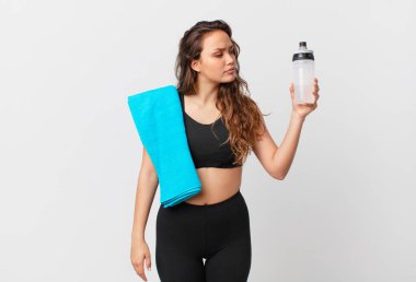 Profil görünümlü genç, güzel bir kadın hayal kuruyor ya da hayal kuruyor. fitness konsepti