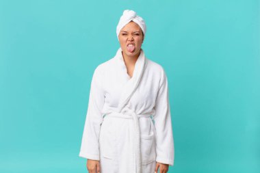 Genç ve güzel bir kadın, tiksinmiş ve rahatsız olmuş hissediyor ve duştan sonra banyo cübbesi giyiyor.
