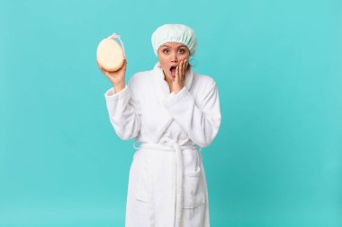 Genç ve güzel bir kadın şok olmuş ve korkmuş hissediyor ve duştan sonra bornoz giyiyor.