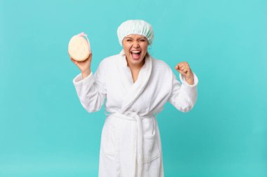 Genç ve güzel bir kadın sinirli bir ifadeyle bağırıyor ve duştan sonra banyo cübbesi giyiyor.