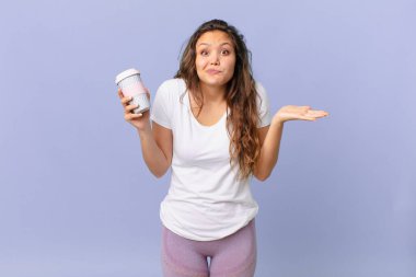Genç, güzel bir kadın şaşkın, şaşkın, şüpheci ve elinde kahve tutan