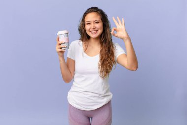 Genç, güzel bir kadın kendini mutlu hissediyor. Onayını gösteriyor.