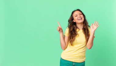 Genç, güzel bir kadın mutlu bir şekilde gülümsüyor, el sallıyor, seni selamlıyor ve fotokopi alanını işaret ediyor.