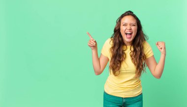 Genç ve güzel bir kadın sinirli bir ifadeyle bağırıyor ve fotokopi alanını işaret ediyor.