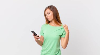 Güzel bir kadın stresli, endişeli, yorgun ve hayal kırıklığına uğramış ve akıllı telefon kullanıyor.