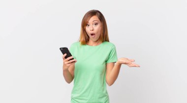 Güzel bir kadın inanılmaz bir sürprizle şaşırmış, şaşırmış ve şaşırmış ve akıllı telefon kullanmış.