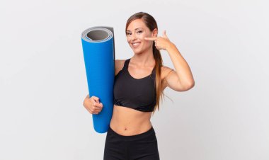 Kendine güvenen güzel bir kadın kendi gülüşünü işaret ediyor. yoga konsepti