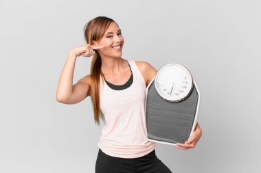 Kendine güvenen güzel bir kadın kendi gülüşünü işaret ediyor. diyet kavramı