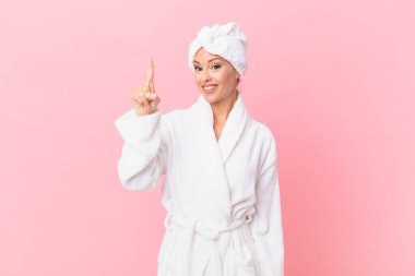 Güzel bayan gülümsüyor ve arkadaş canlısı görünüyor, bir numarayı gösteriyor. spa konsepti