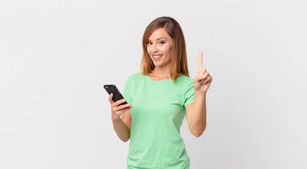 Mulher Bonita Sorrindo Olhando Amigável Mostrando Número Usando Smartphone — Fotografia de Stock