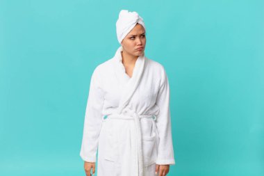 Genç, güzel bir kadın üzgün, üzgün ya da kızgın ve duştan sonra banyo cübbesi giyiyor.