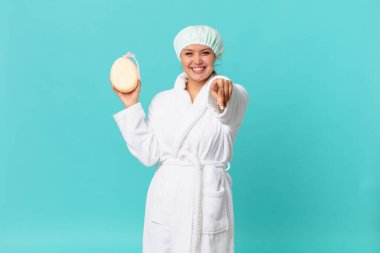 Genç ve güzel bir kadın kamerayı işaret ederek seni seçiyor ve duştan sonra banyo cübbesi giyiyor.