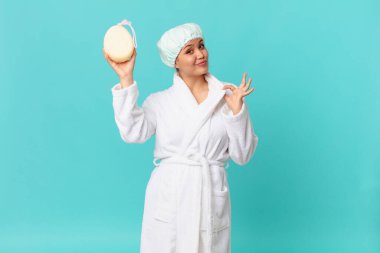 Genç, güzel bir kadın kibirli, başarılı, pozitif ve gururlu görünüyor ve duştan sonra bornoz giyiyor.