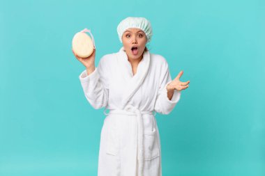 Genç, güzel bir kadın şok olmuş, şaşırmış ve duştan sonra bornoz giyiyor.