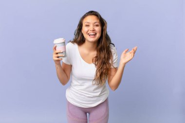 Genç, güzel bir kadın kendini mutlu hissediyor. Çözümü ya da fikri fark edip elinde kahve tutmasına şaşırıyor.