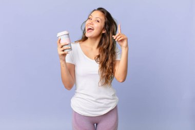 Genç ve güzel bir kadın bir fikri fark ettikten ve elinde kahve tutduktan sonra mutlu ve heyecanlı bir dahi gibi hissediyor.