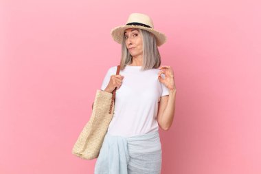 Orta yaşlı beyaz saçlı kadın kibirli, başarılı, pozitif ve gururlu görünüyor. yaz konsepti