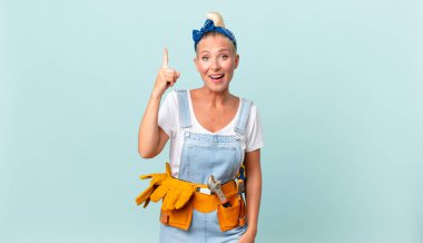 Güzel sarışın kadın bir fikri fark ettikten ve ev konseptini düzelttikten sonra mutlu ve heyecanlı bir dahi gibi hissediyor.