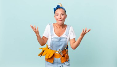 Güzel sarışın kadın şok olmuş, şaşırmış ve ev konseptini düzeltiyor.