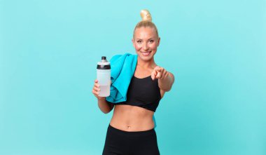 Güzel sarışın kadın seni seçen kamerayı işaret ediyor. fitness konsepti