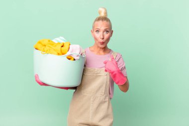 Güzel sarışın kadın kendini mutlu hissediyor ve heyecanlı çamaşır konseptiyle kendini işaret ediyor.