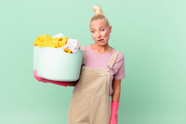 Güzel sarışın kadın şaşkın ve kafası karışmış çamaşır yıkama konsepti