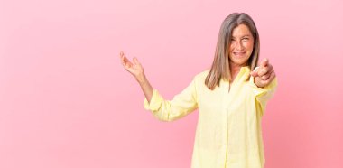 Güzel orta yaşlı bir kadın kamerayı işaret ederek seni seçiyor.