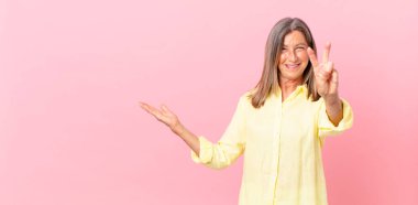 Güzel orta yaşlı bir kadın gülümsüyor ve arkadaş canlısı görünüyor.